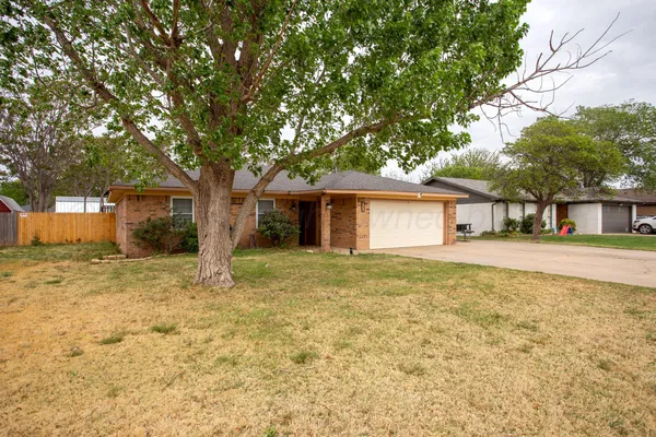 a front view of house with yard and trees around