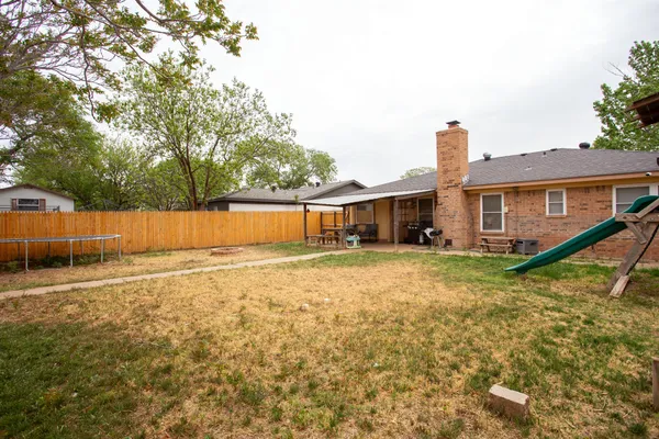 a view of a house with backyard and a tree