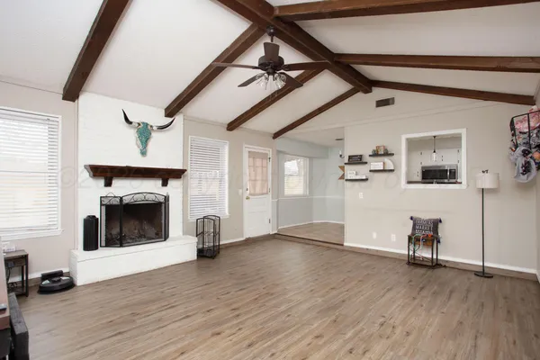 a view of empty room with wooden floor and fireplace