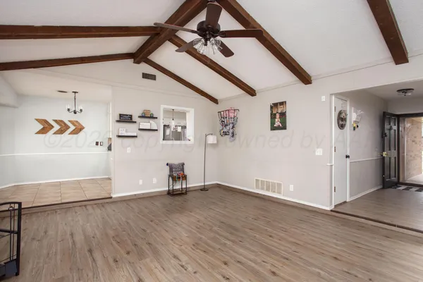 a view of a livingroom with wooden floor and a ceiling fan