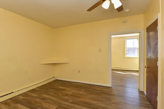 a view of empty room with wooden floor