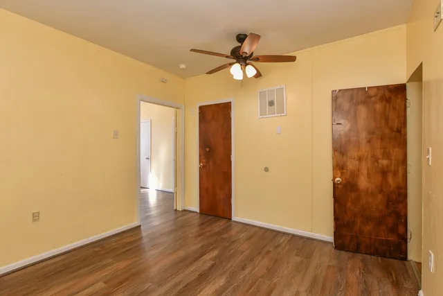 a view of a livingroom with wooden floor and a ceiling fan