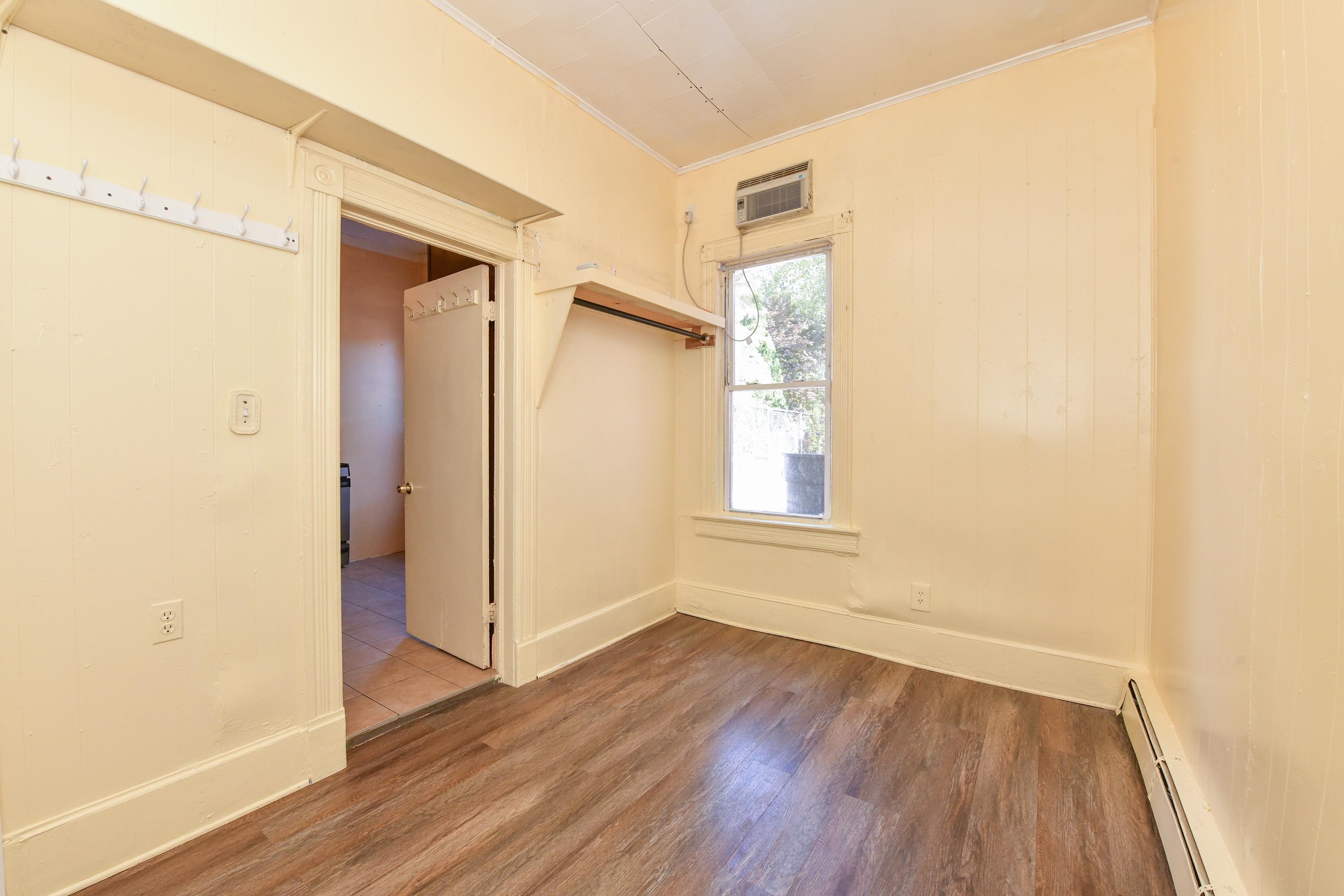 208 4th Street, Unit 1 Passaic, NJ 07055 - Photo 21 of 28 an empty room with wooden floor and a window