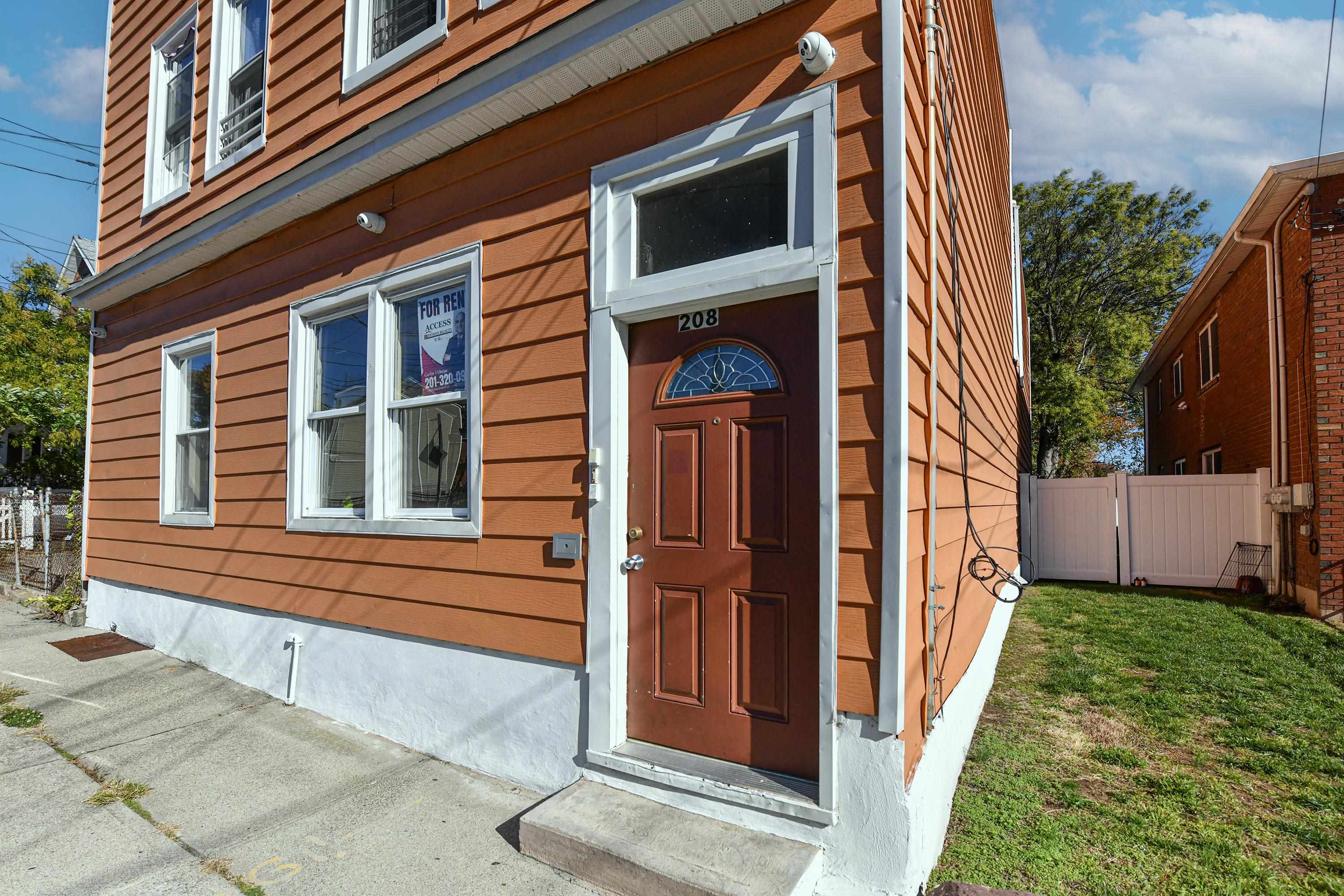 208 4th Street, Unit 1 Passaic, NJ 07055 - Photo 4 of 28 a front view of a house with a yard