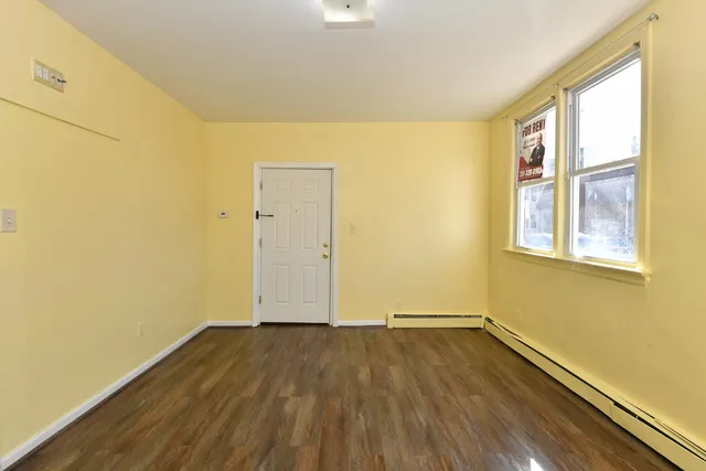a view of a room with wooden floor and brick walls