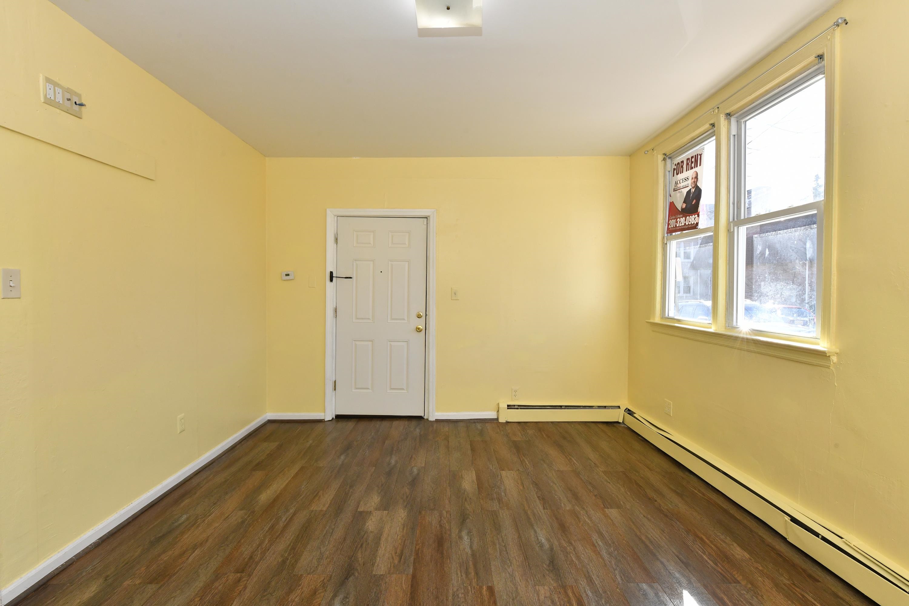 208 4th Street, Unit 1 Passaic, NJ 07055 - Photo 8 of 28 a view of a room with wooden floor and brick walls
