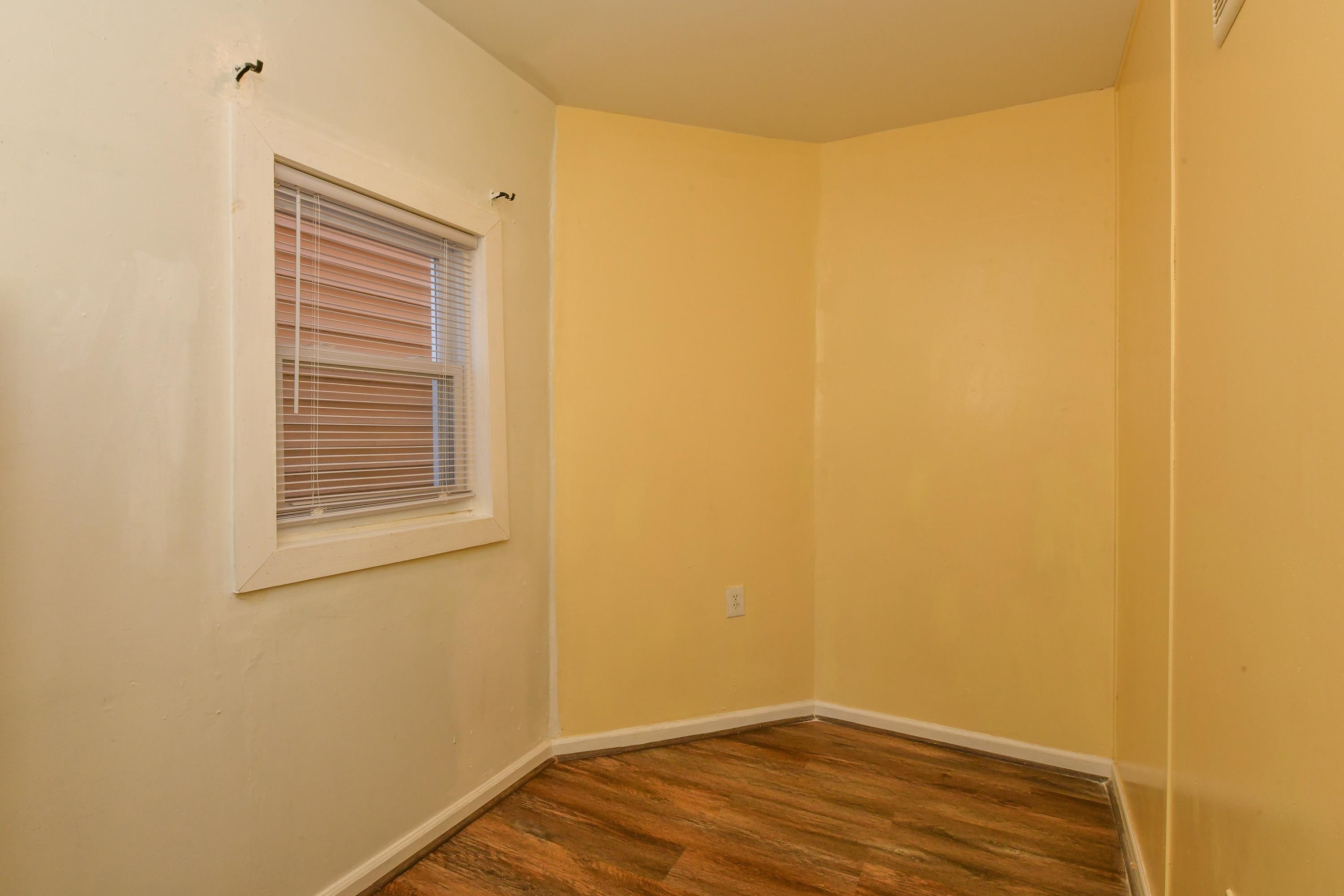 208 4th Street, Unit 1 Passaic, NJ 07055 - Photo 9 of 28 a view of an empty room with wooden floor and a window