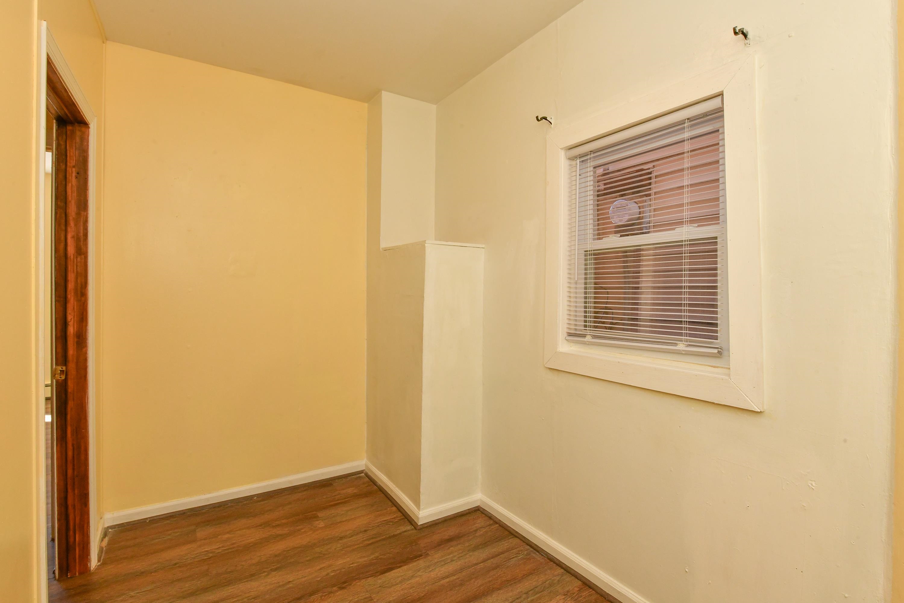 208 4th Street, Unit 1 Passaic, NJ 07055 - Photo 10 of 28 a view of an empty room with wooden floor and a window