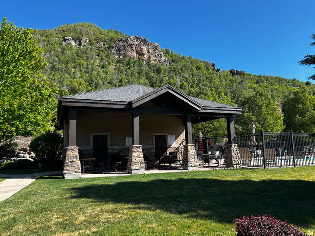 1154 Sunset Dunes Way Draper, UT 84020 - Photo 5 of 50 Poolside clubhouse featuring a gabled roofline, stone column bases, and an adjacent fenced swimming area