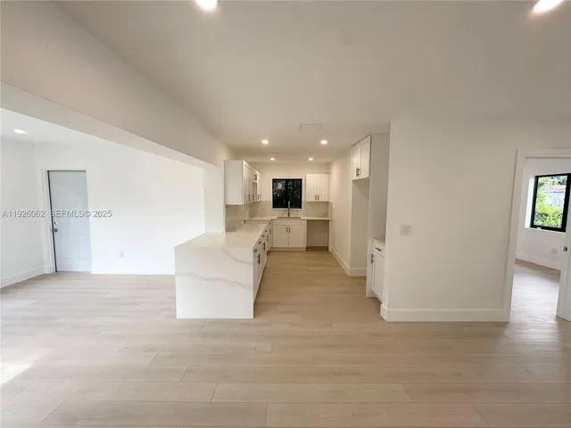 a dining room with furniture potted plants and wooden floor