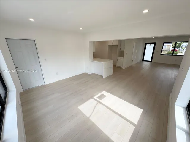a large white kitchen with white cabinets and a refrigerator
