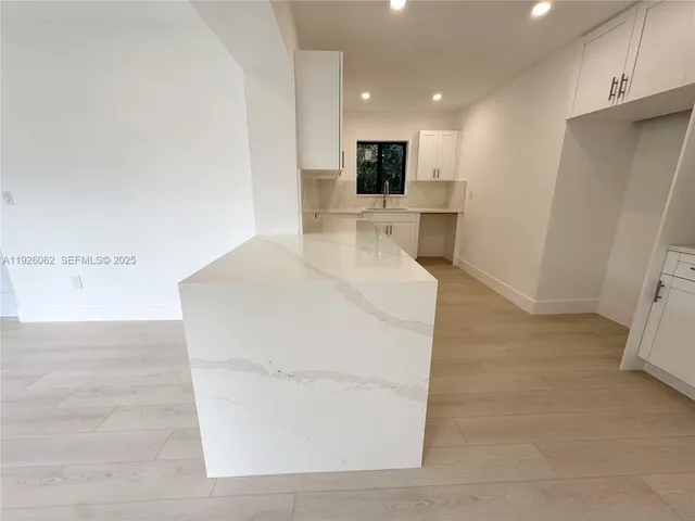 a kitchen with white cabinets white appliances and sink