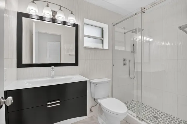 a bathroom with a toilet a sink and mirror