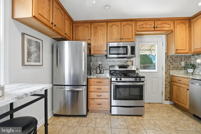 a kitchen with stainless steel appliances granite countertop a refrigerator stove and oven