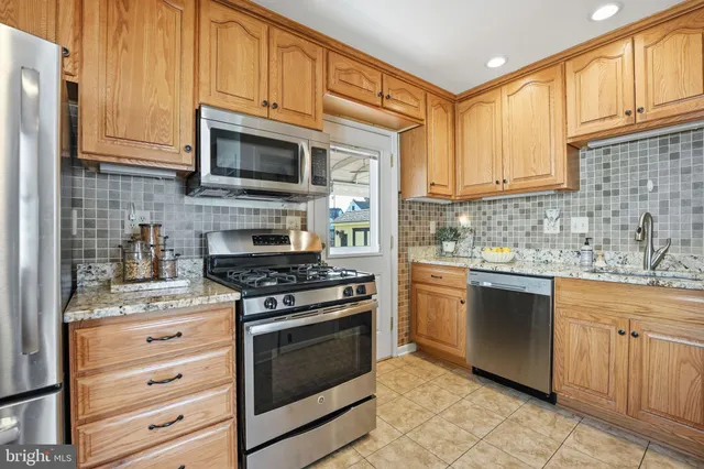a kitchen with stainless steel appliances granite countertop a stove microwave and cabinets