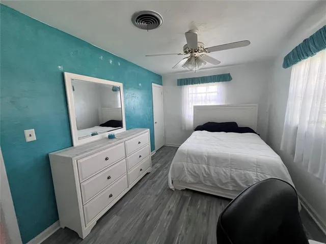 a bedroom with a bed and a flat tv screen on dresser