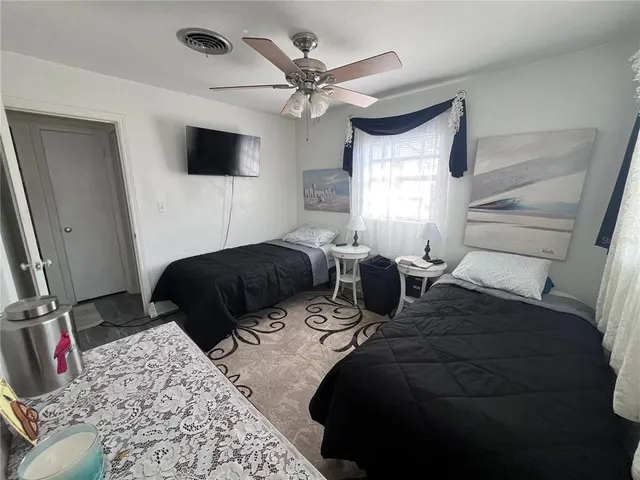 a bedroom with a bed a window and a flat screen tv