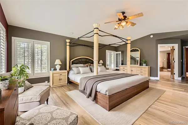 a bedroom with a bed a chandelier and balcony
