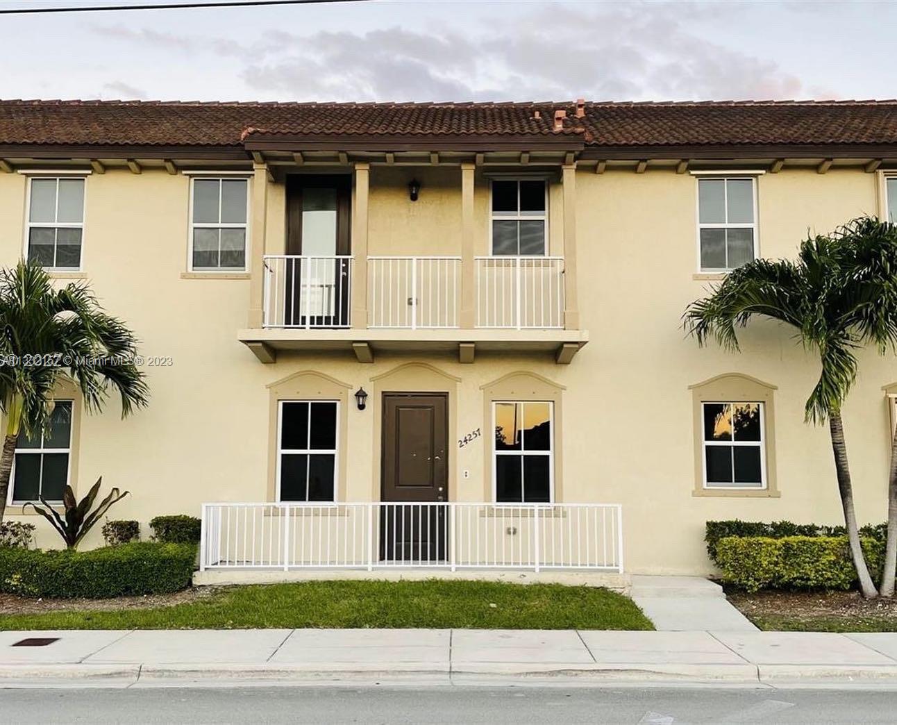 24257 Southwest 117th Avenue Homestead, FL 33032 - Photo 1 of 27 a view of a white house with a large window and potted plants