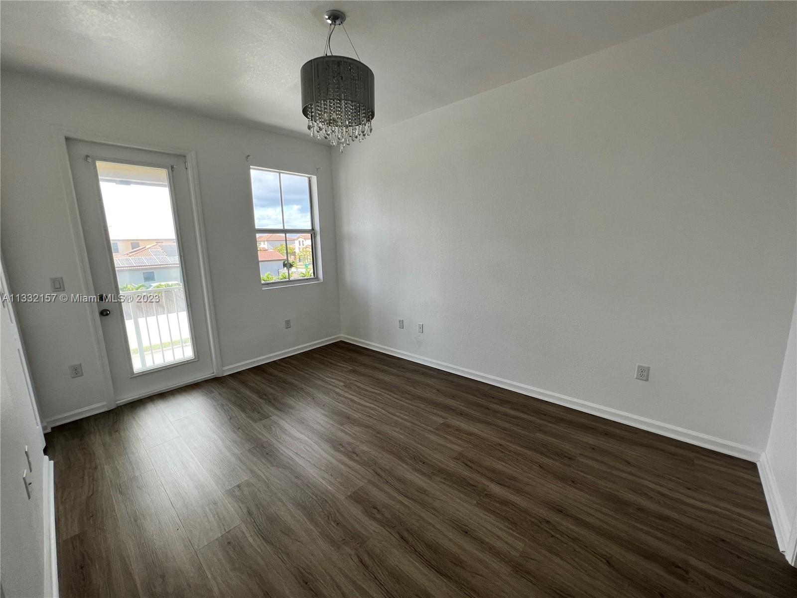 24257 Southwest 117th Avenue Homestead, FL 33032 - Photo 23 of 27 an empty room with wooden floor and windows