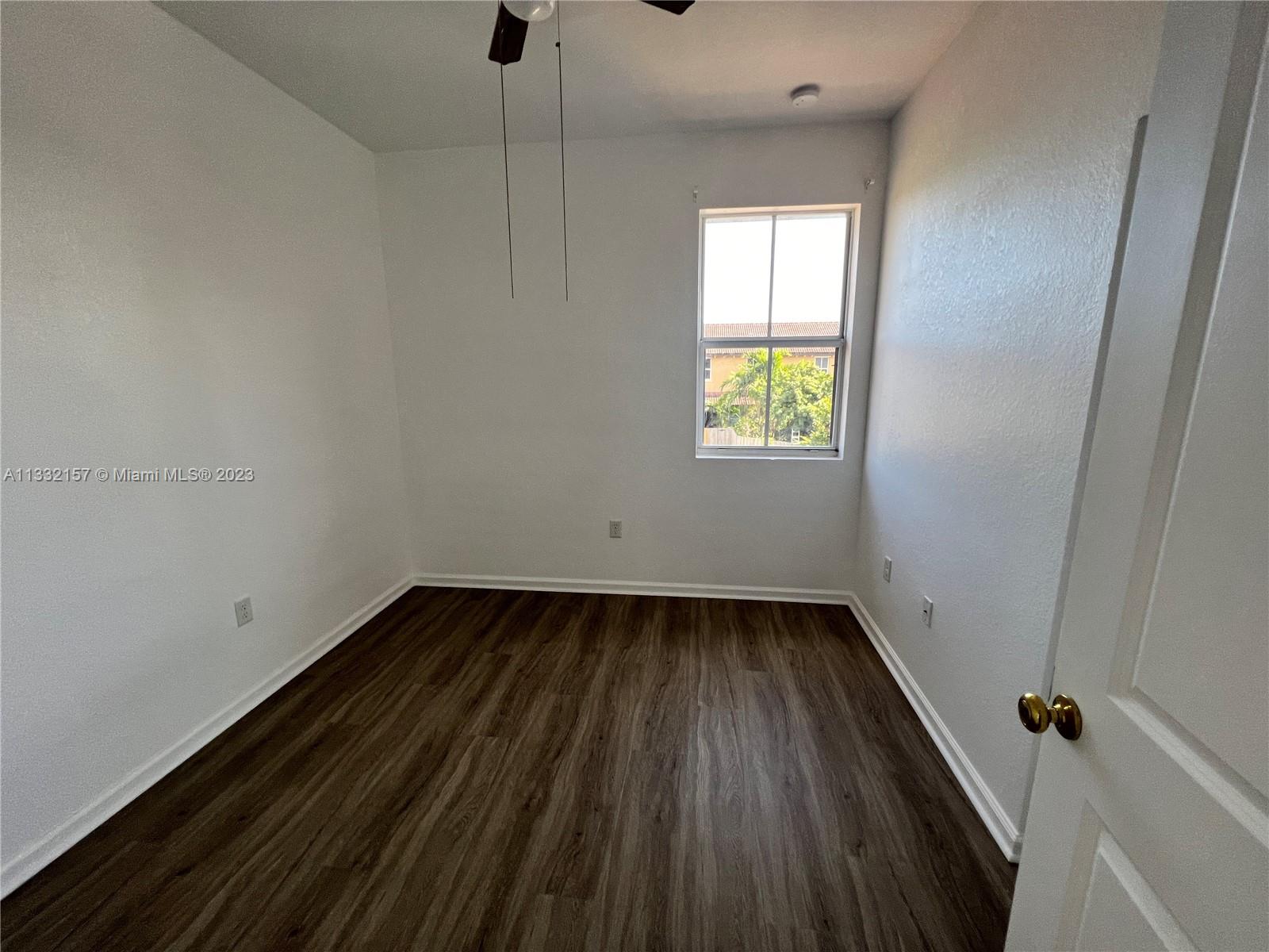 24257 Southwest 117th Avenue Homestead, FL 33032 - Photo 24 of 27 a view of an empty room with wooden floor and a window