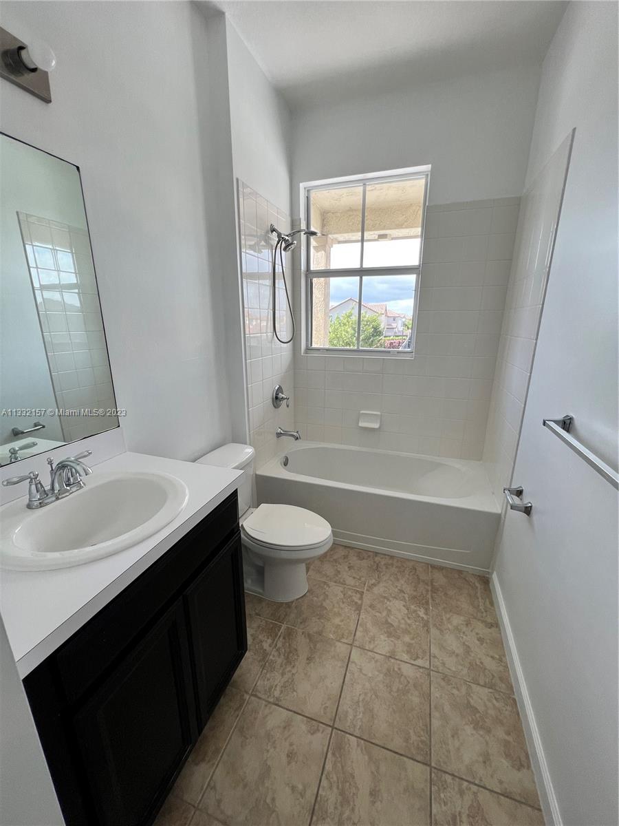 24257 Southwest 117th Avenue Homestead, FL 33032 - Photo 25 of 27 a bathroom with a sink toilet double vanity and mirror