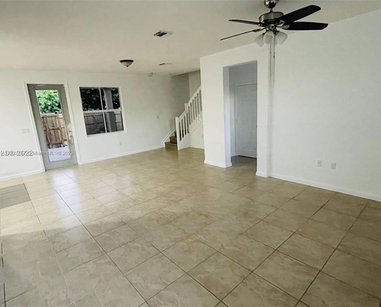 24257 Southwest 117th Avenue Homestead, FL 33032 - Photo 9 of 27 an empty room with a ceiling fan and glass door