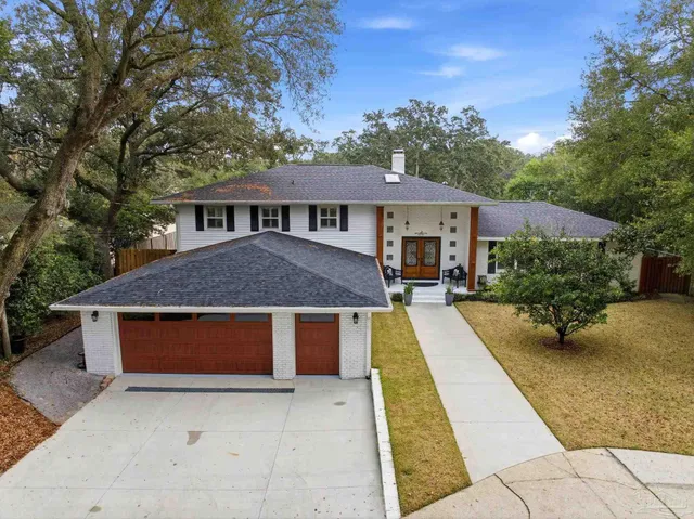 a front view of a house with yard porch and glass top table and chairs