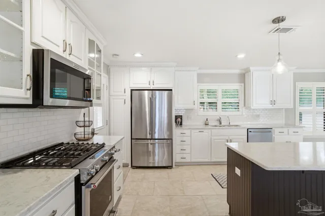 a kitchen with refrigerator a sink a stove a microwave and island