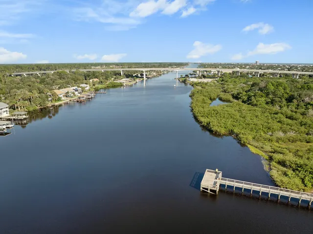 an aerial view of ocean and residential houses with outdoor space