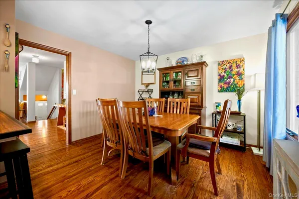 a dining room with furniture wooden floor a rug and a chandelier