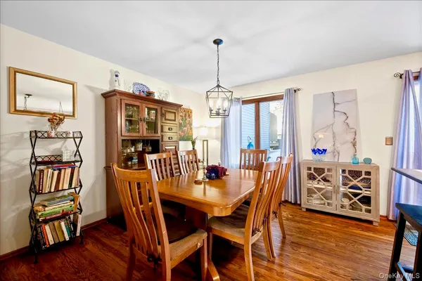 a dining room with furniture window wooden floor and a chandelier