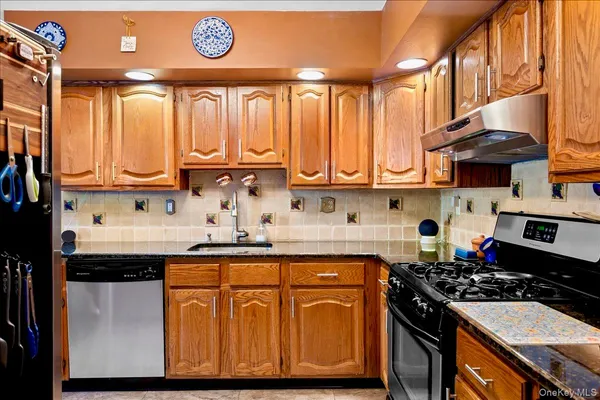 a kitchen with stainless steel appliances granite countertop a stove a sink and a microwave