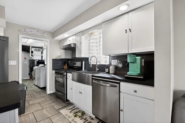 a kitchen with a sink cabinets and stainless steel appliances