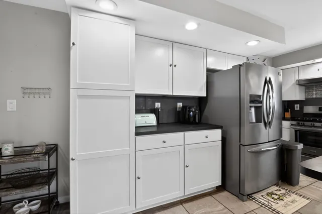 a kitchen with appliances a refrigerator and cabinets
