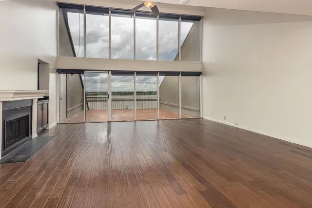an empty room with wooden floor and fireplace