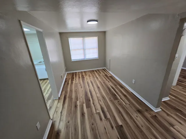 wooden floor in an empty room with a window