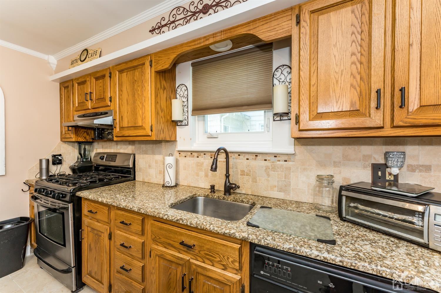 729 Livingston Road Elizabeth, NJ 07208 - Photo 11 of 26 a kitchen with granite countertop a sink stove and cabinets