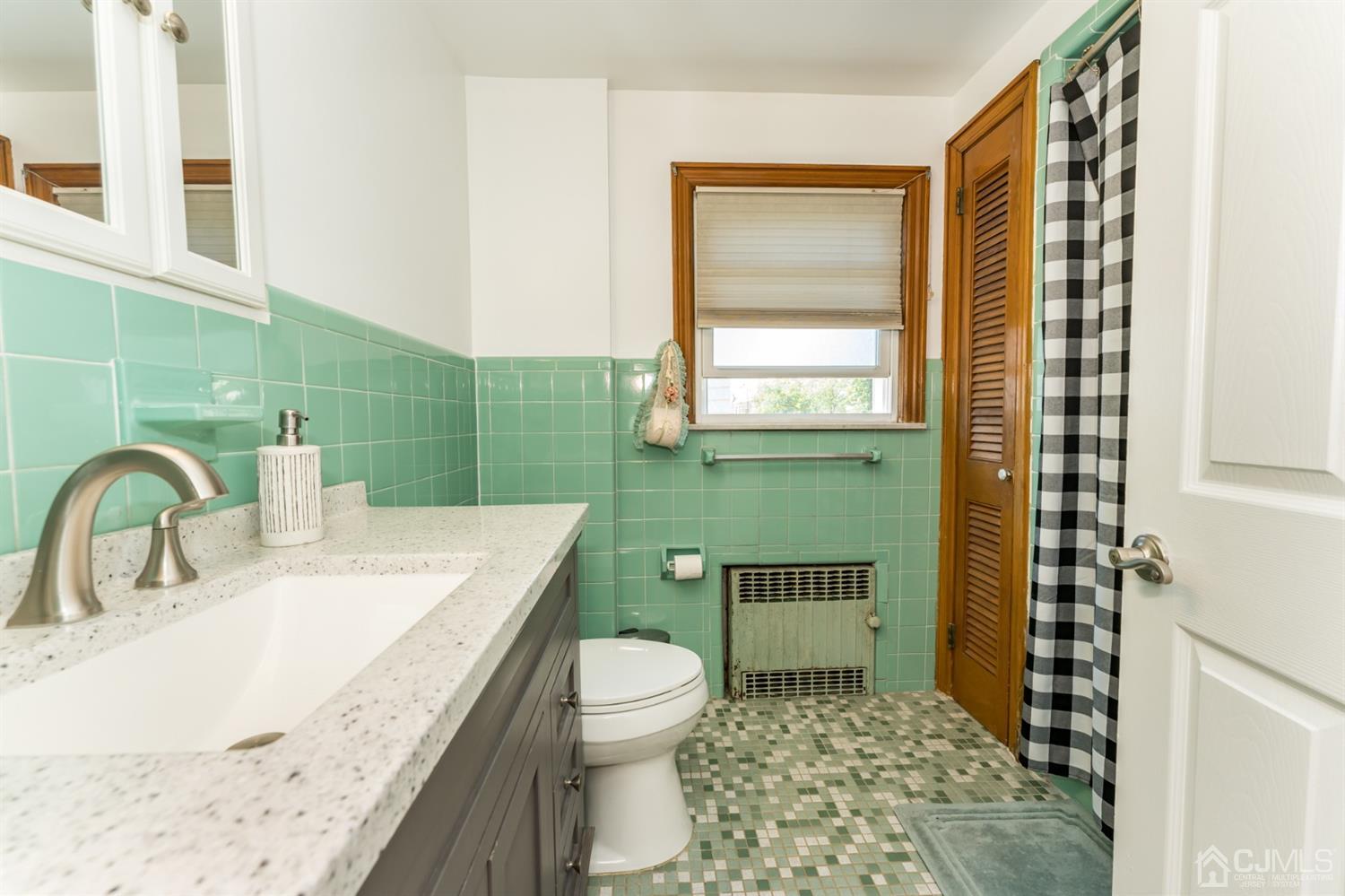 729 Livingston Road Elizabeth, NJ 07208 - Photo 22 of 26 a bathroom with a granite countertop sink a toilet and shower