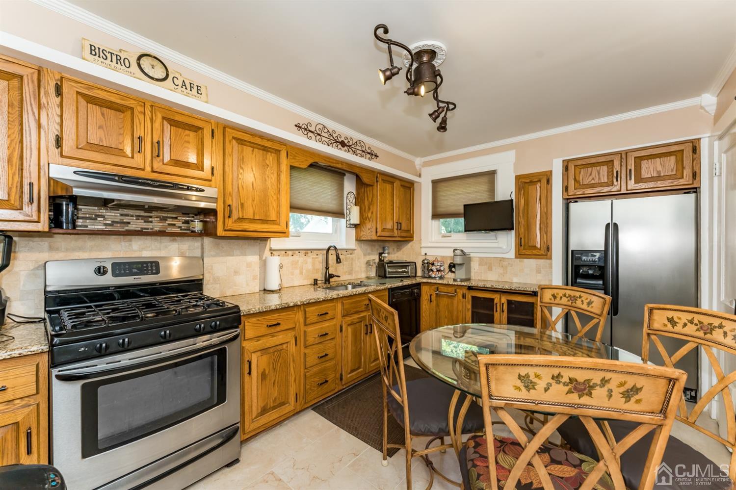 729 Livingston Road Elizabeth, NJ 07208 - Photo 9 of 26 a kitchen with stainless steel appliances granite countertop a stove top oven a sink dishwasher a dining table and chairs with wooden floor