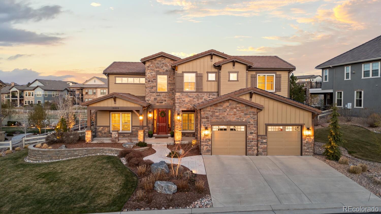a view of a big house with large windows and a yard