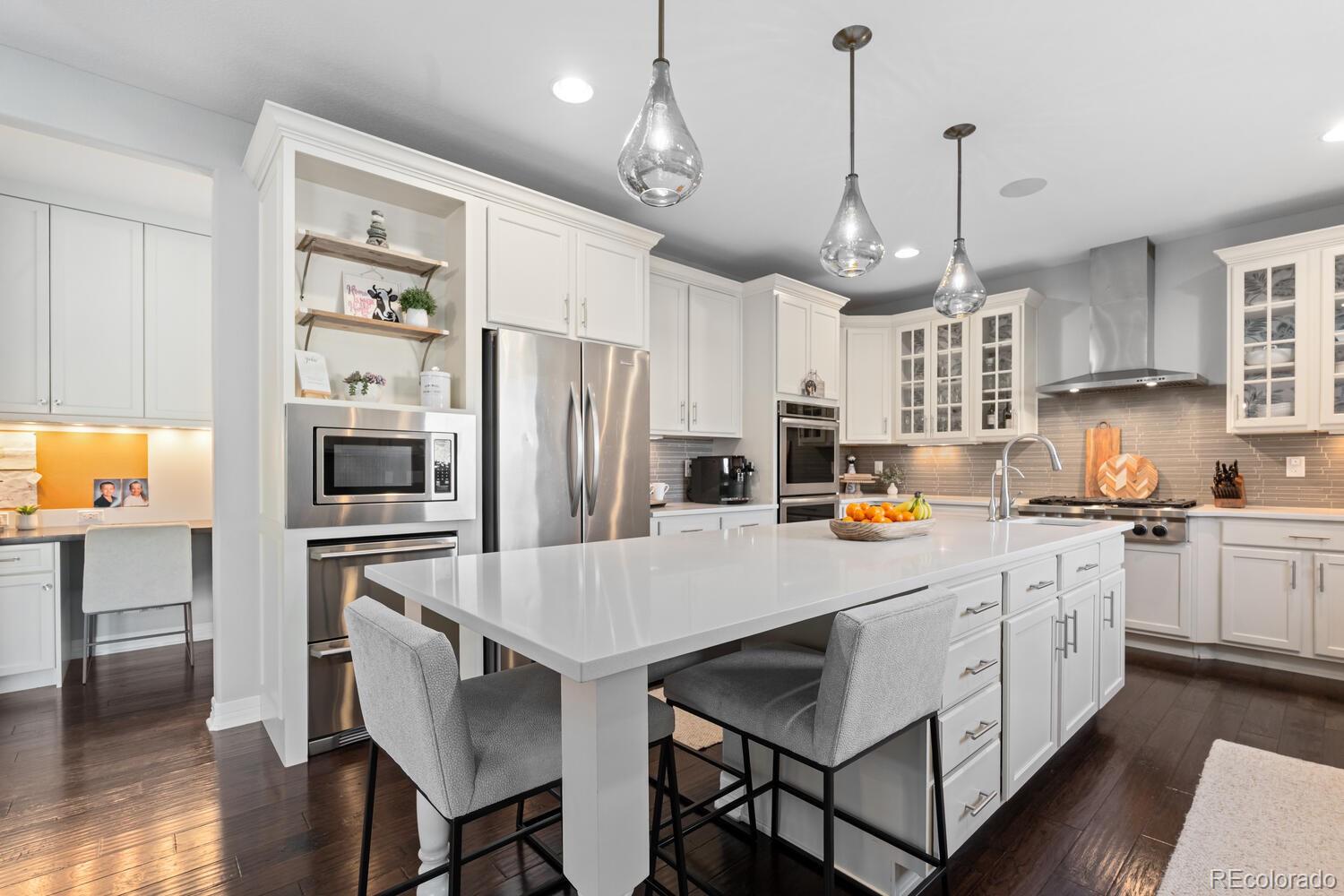 10800 Sundial Rim Road Highlands Ranch, CO 80126 - Photo 14 of 48 a kitchen with stainless steel appliances a stove center island refrigerator and a cabinets