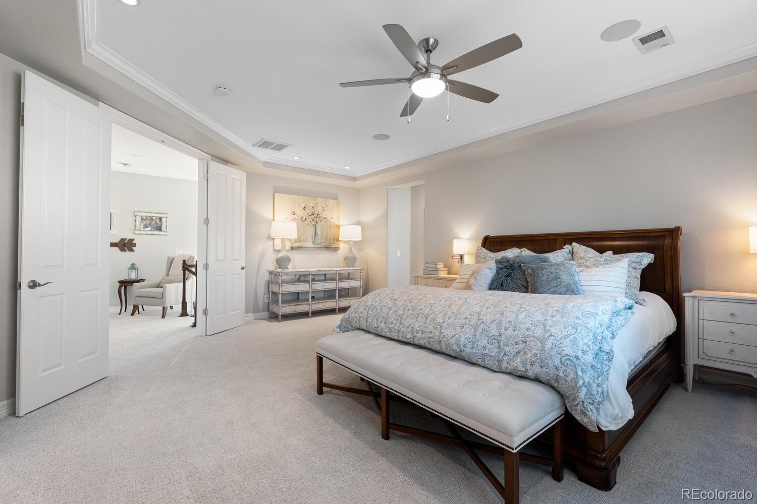 10800 Sundial Rim Road Highlands Ranch, CO 80126 - Photo 22 of 48 a spacious bedroom with a bed a couch and a chandelier