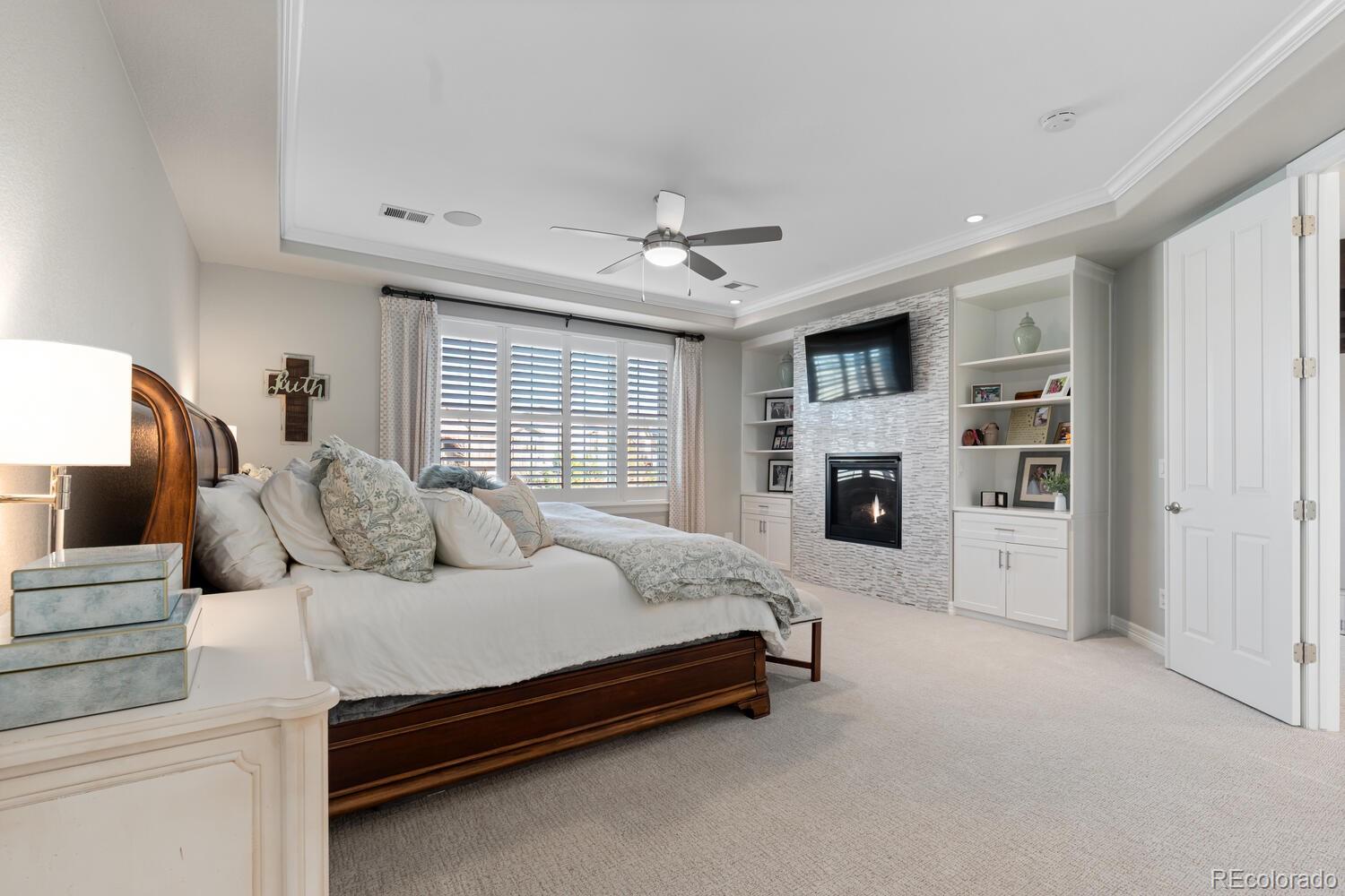 10800 Sundial Rim Road Highlands Ranch, CO 80126 - Photo 23 of 48 a spacious bedroom with a bed and a fireplace