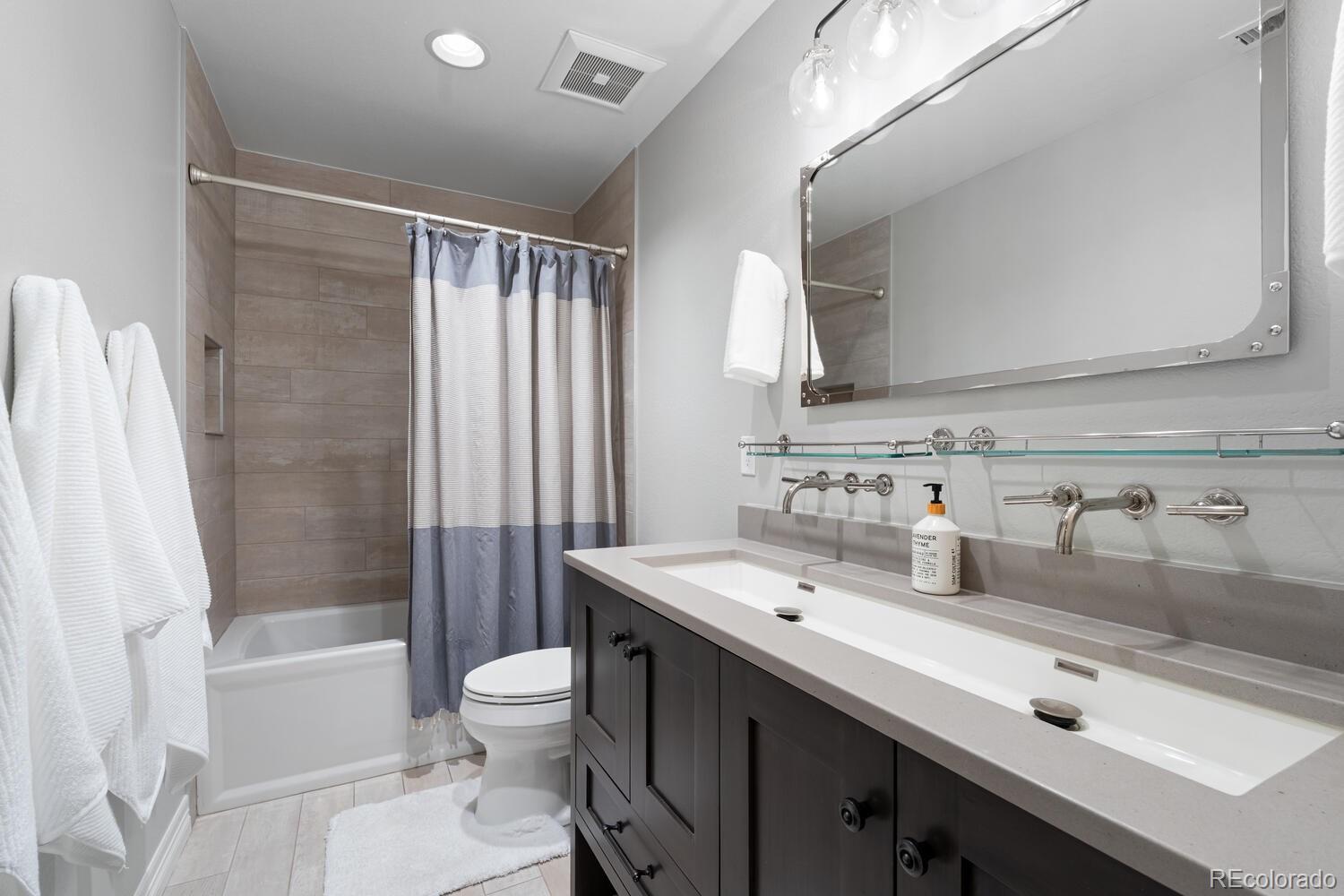 10800 Sundial Rim Road Highlands Ranch, CO 80126 - Photo 38 of 48 a bathroom with a double vanity sink toilet mirror and shower