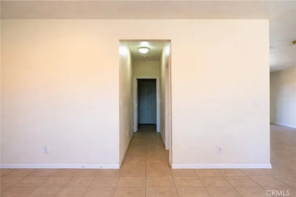 a view of an empty room with closet and mirror
