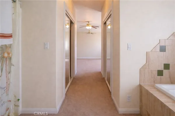 a view of a hallway with a refrigerator and a sink