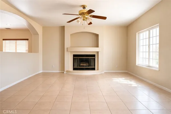a view of an empty room with window and a fireplace