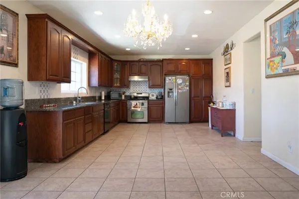 a kitchen with stainless steel appliances granite countertop a refrigerator and a stove top oven