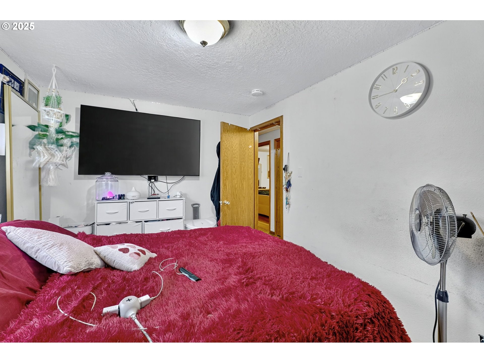 8739 Southeast Knapp Street Portland, OR 97266 - Photo 15 of 23 a bedroom with a bed and a flat screen tv